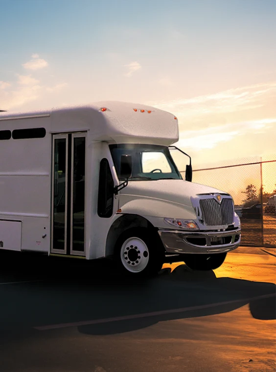 White shuttle bus parked next to a security fence at a prison near Buffalo